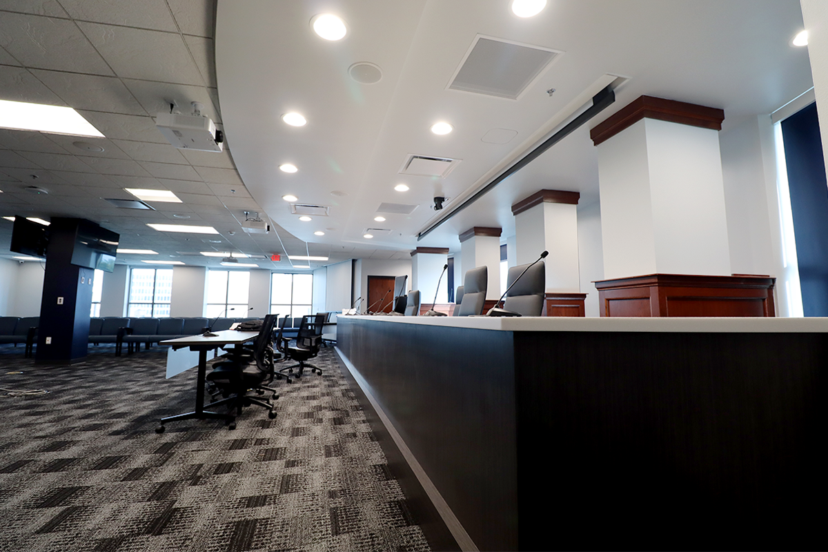 The South Bend City Council chamber features a raised podium with a white countertop and gray cabinet for the Council Members to site behdin