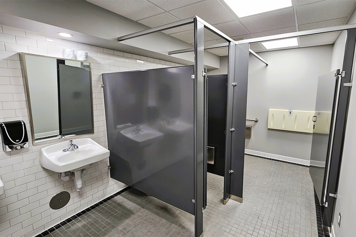 Hiler Building restroom renovations with new tile flooring and gray partitions