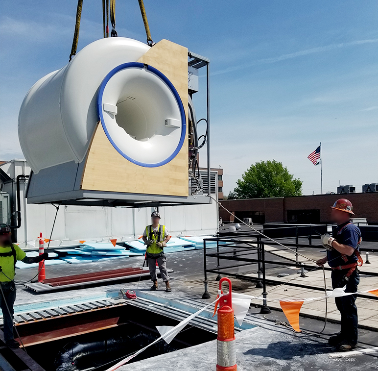 A Facility Services Group team moves an MRI machine at a project