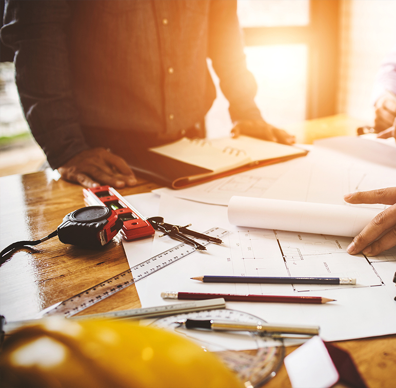conceptual image of pre-construction services with engineering and architectural tools on a table