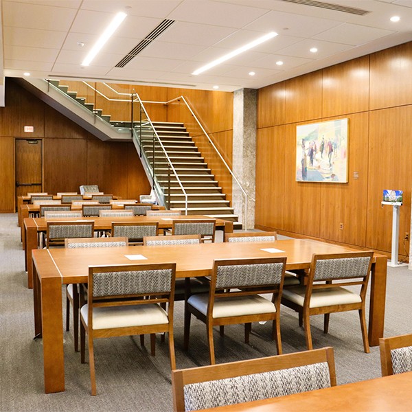 A row of library desks sits in front of a grand staircase as example of our education construction services