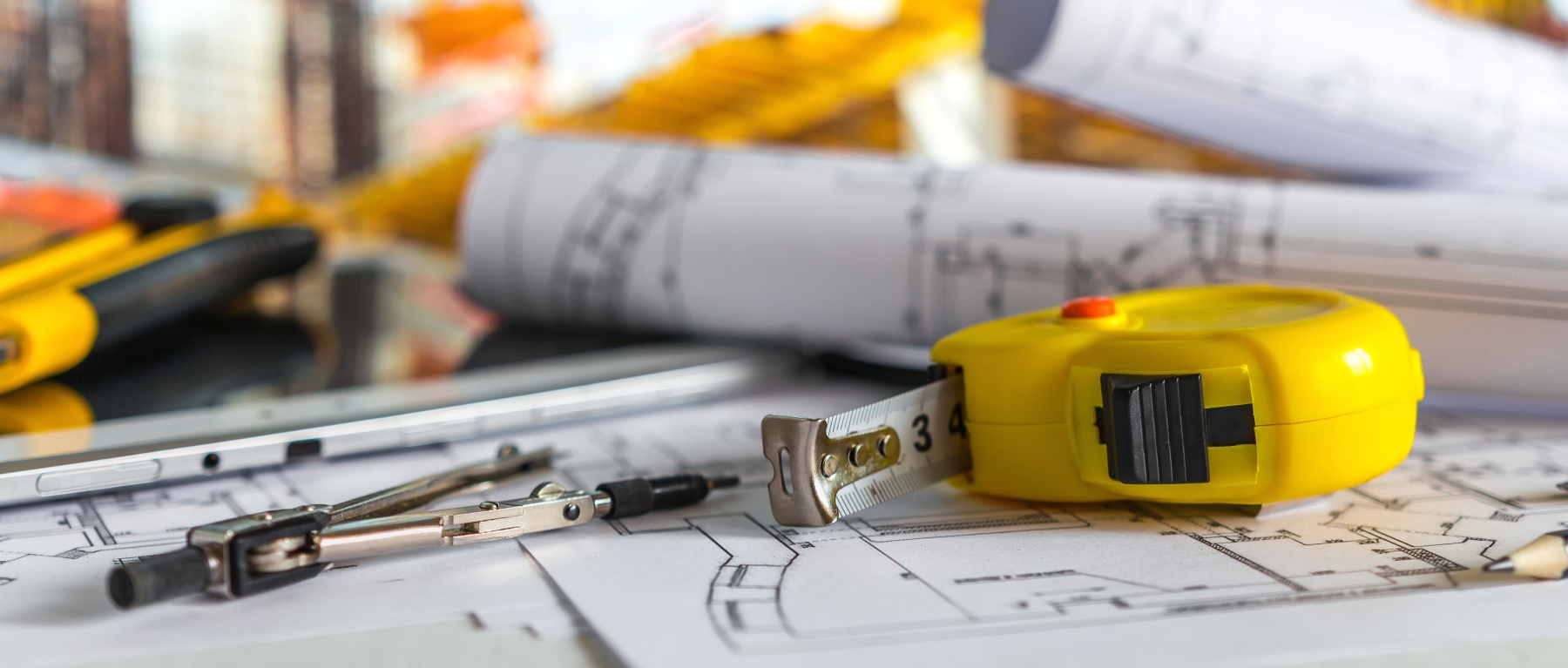 rolls of plans, construction plans, tap measure, and engineering tools